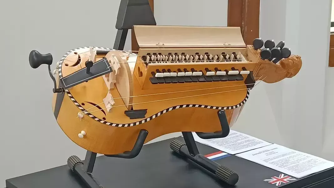 Gitaarvormige draailier, gepresenteerd op een statief voor instrumenten.